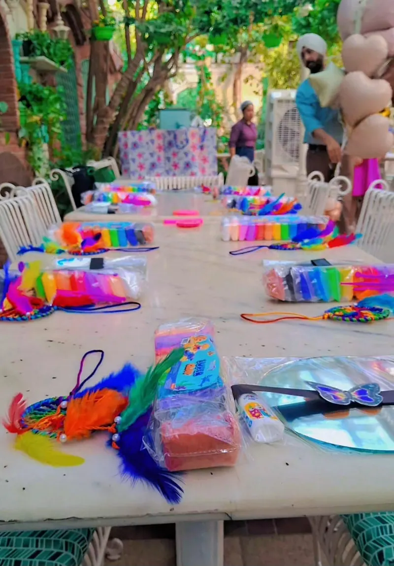 Café table laid with mirrors, coloured air-dry clay packs and dreamcatcher kits for a kids' birthday Clay Mirror Art workshop in Delhi — Kraftykinni